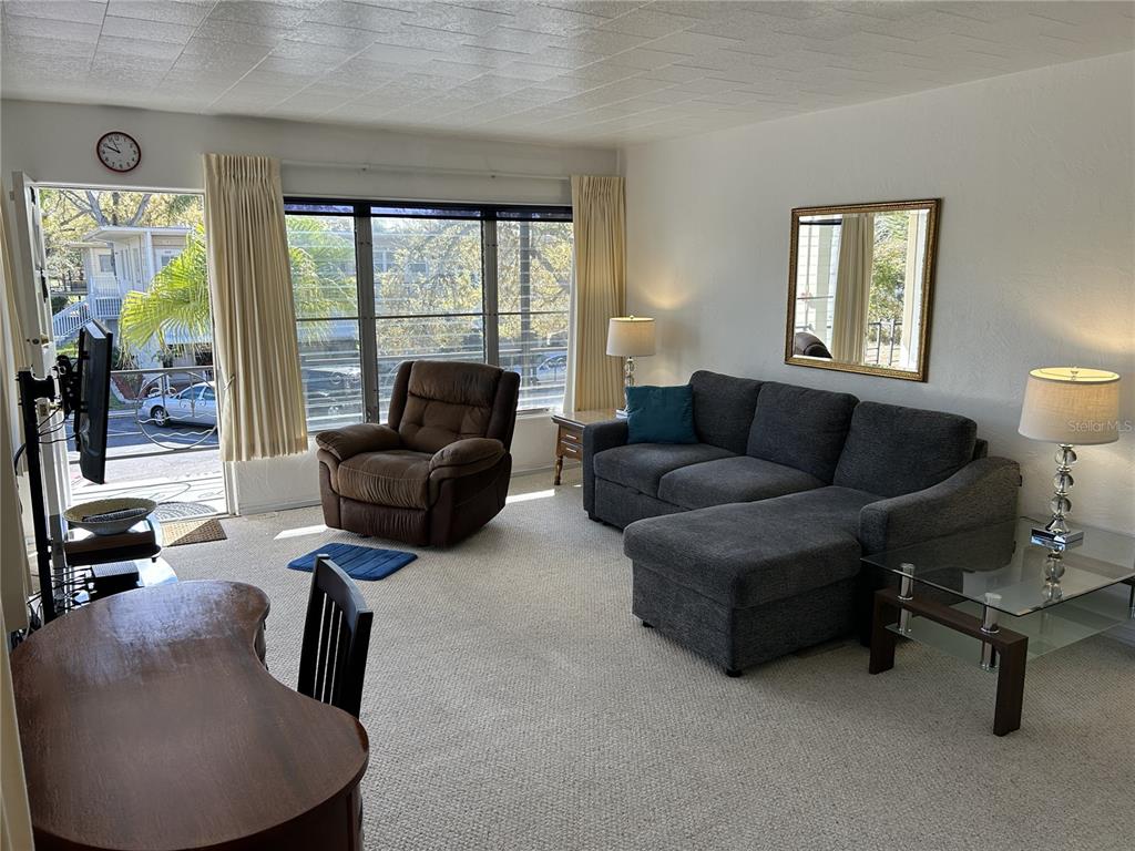 A living room features a gray sectional sofa, a brown recliner, and a glass-topped table — 4154 57TH STREET N UNIT 274, KENNETH CITY, FL