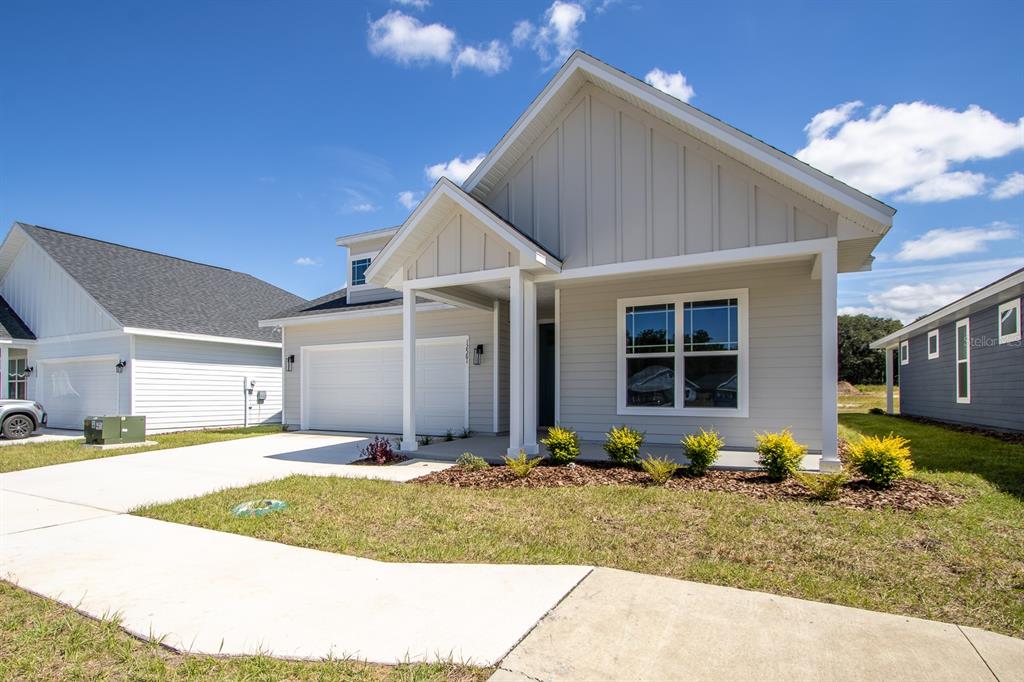 A light gray single-story house with a white garage and a front porch — 12581 NW 159TH WAY, ALACHUA, FL