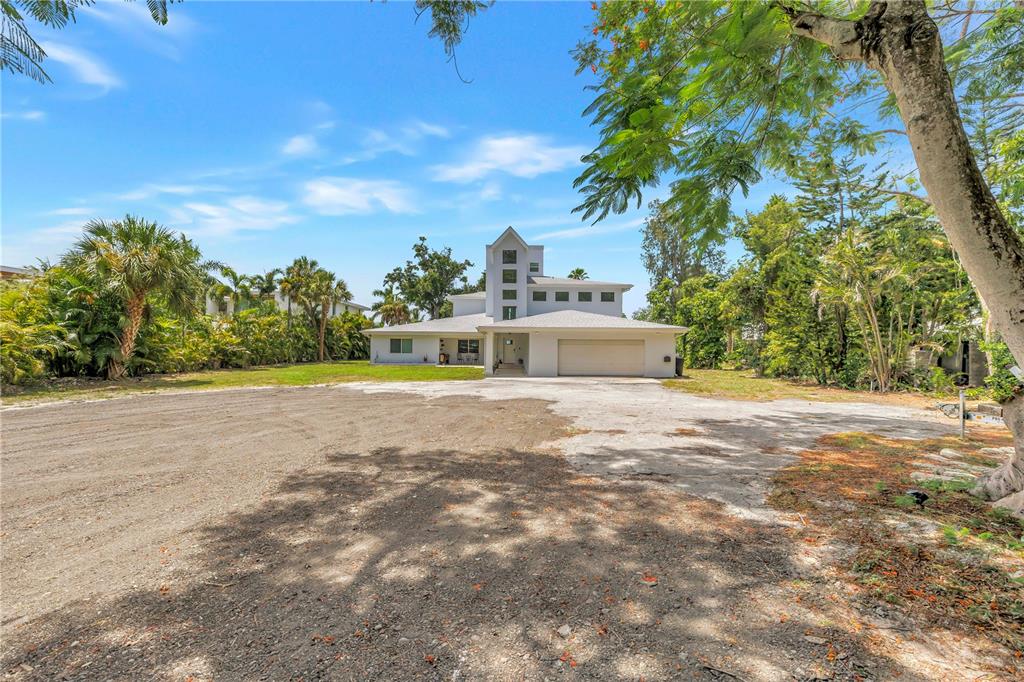 A multi-story house with a large garage and a wide, unpaved dirt driveway — 2280 PINELLAS POINT DRIVE S, ST PETERSBURG, FL