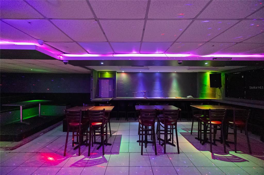 A dimly lit lounge area features tiled floors, bar seating, and colorful accent lighting — 239 C ELEANOR ROOSEVELT, SAN JUAN, PR