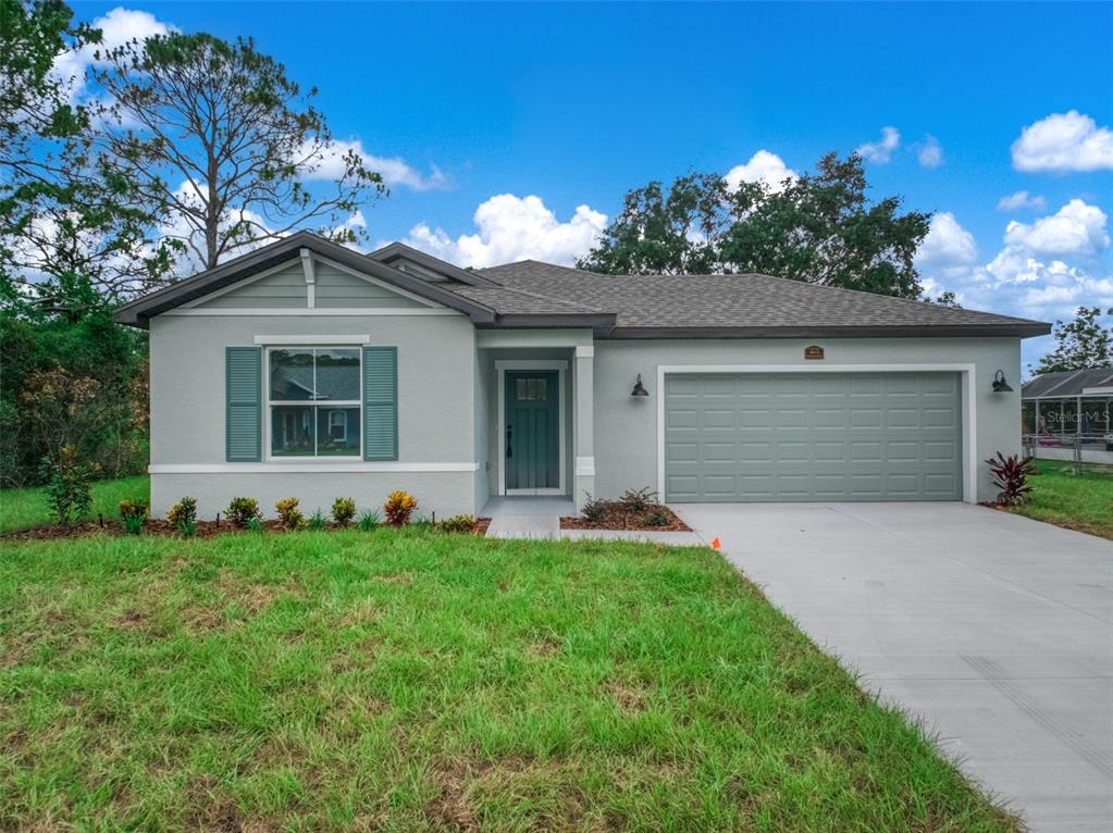 A single-story house with light gray stucco, a green garage door, and a front lawn — 4015 FONSECA AVENUE, SEBRING, FL