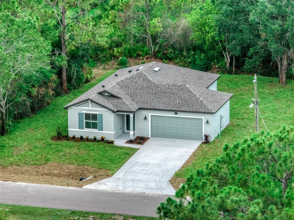 An aerial view of a single-story suburban house with a gray exterior and attached garage — 4015 FONSECA AVENUE, SEBRING, FL