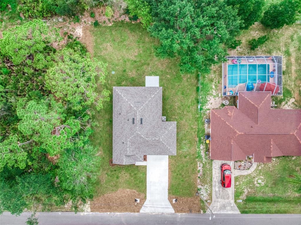 An aerial view shows a house with a gray roof, concrete driveway, and surrounding yard — 4015 FONSECA AVENUE, SEBRING, FL