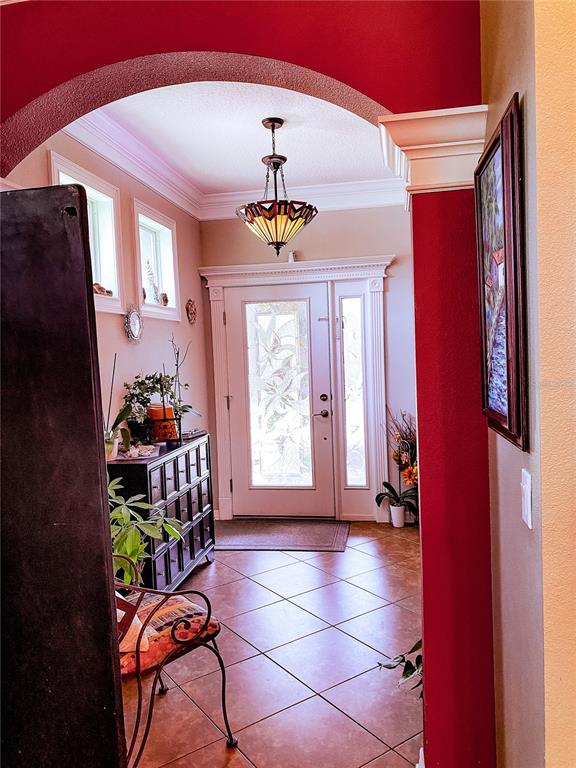 An entryway features a stained-glass front door, tile flooring, and a decorative hanging light fixture — 2379 PICKFORD CIRCLE, APOPKA, FL