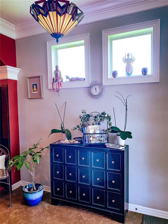 A black dresser sits against a wall with two square windows and a hanging lamp — 2379 PICKFORD CIRCLE, APOPKA, FL