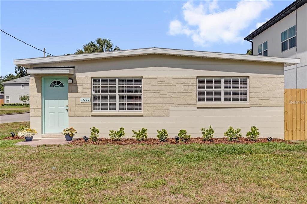 A single-story house with a light-colored facade, a mint green door, and two windows — 1600 HART LANE, ORLANDO, FL