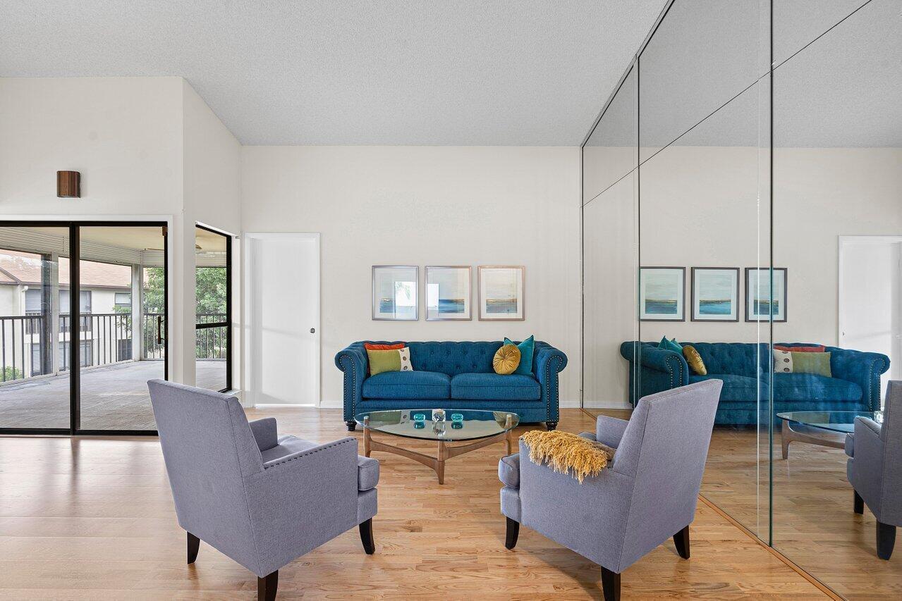 A living room features a blue sofa, two gray armchairs, and a large mirrored wall — 3362 Lucerne Park Drive, FL 33467, FL