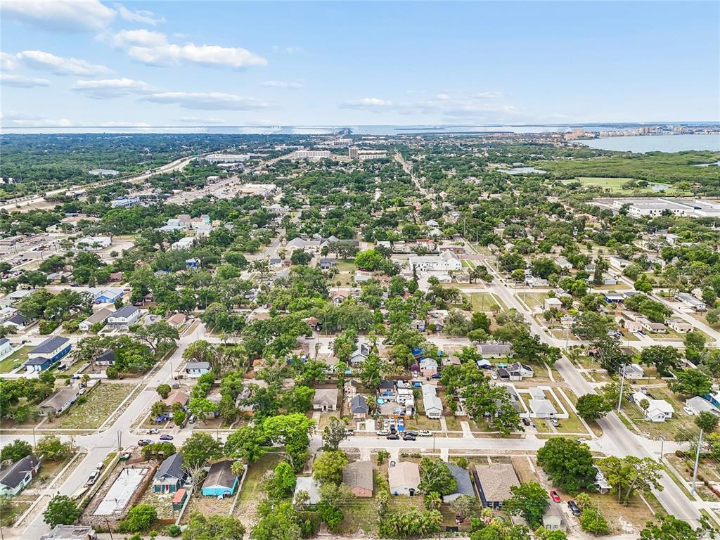 An aerial view shows a suburban neighborhood with houses, trees, and a distant coastline — 3603 16TH AVENUE S, ST PETERSBURG, FL