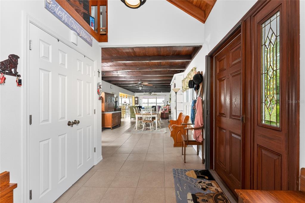 A view from an entryway looking into a dining area with exposed wood ceiling beams — 720 S MCCALL ROAD, ENGLEWOOD, FL