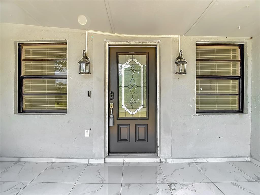 An aerial view shows a house with a swimming pool, patio, and surrounding trees — 1506 S OREGON CIRCLE, TAMPA, FL