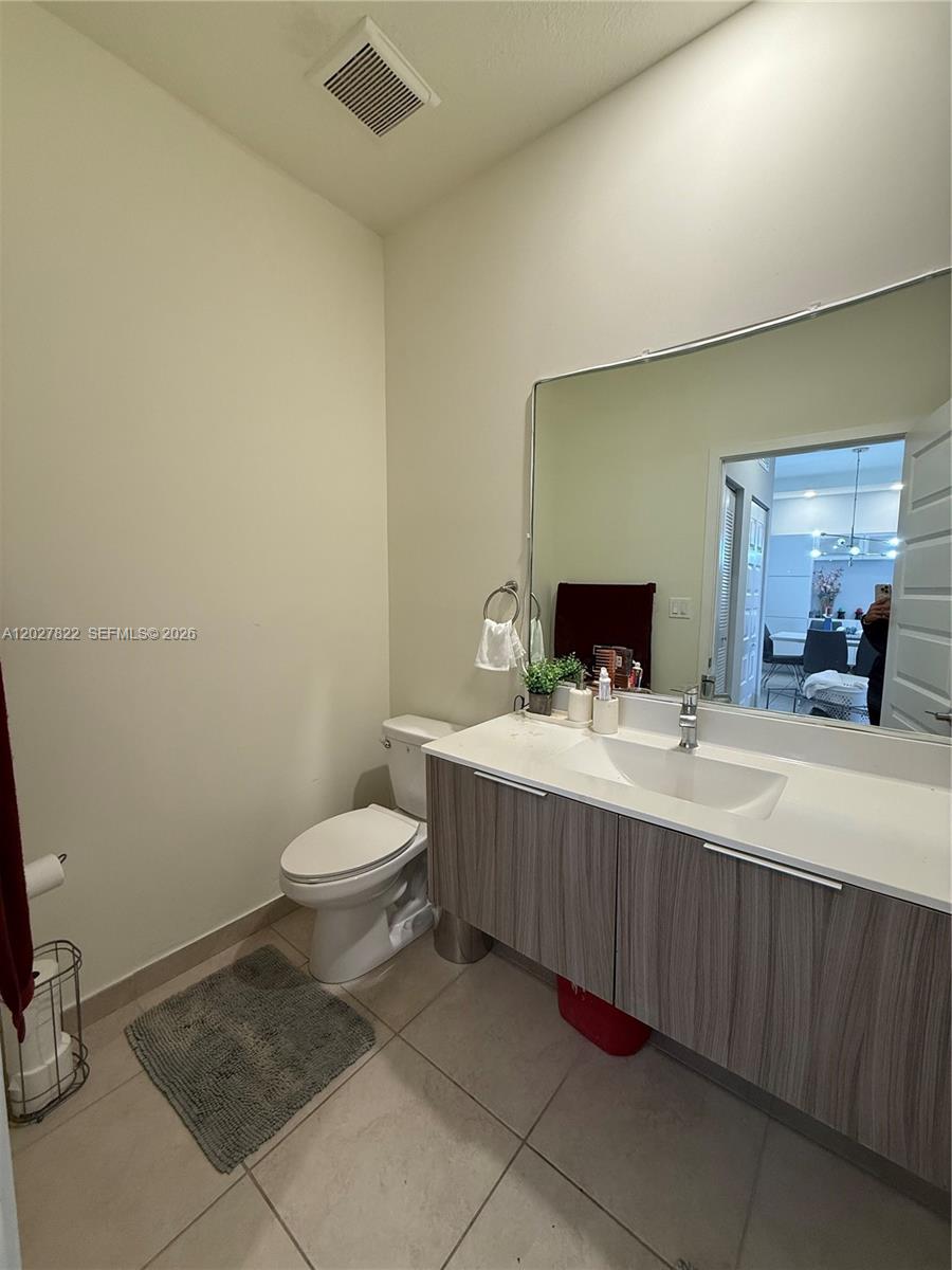 This bathroom features a floating vanity, a large mirror, and a white toilet — 7815 NW 104th Ave # 32, Doral FL 33178, DORAL, FL