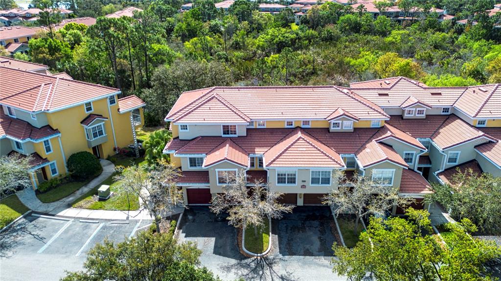 An aerial view shows a multi-story townhouse complex with red tile roofs and yellow siding — 5711 BENTGRASS DRIVE UNIT 19-202, SARASOTA, FL