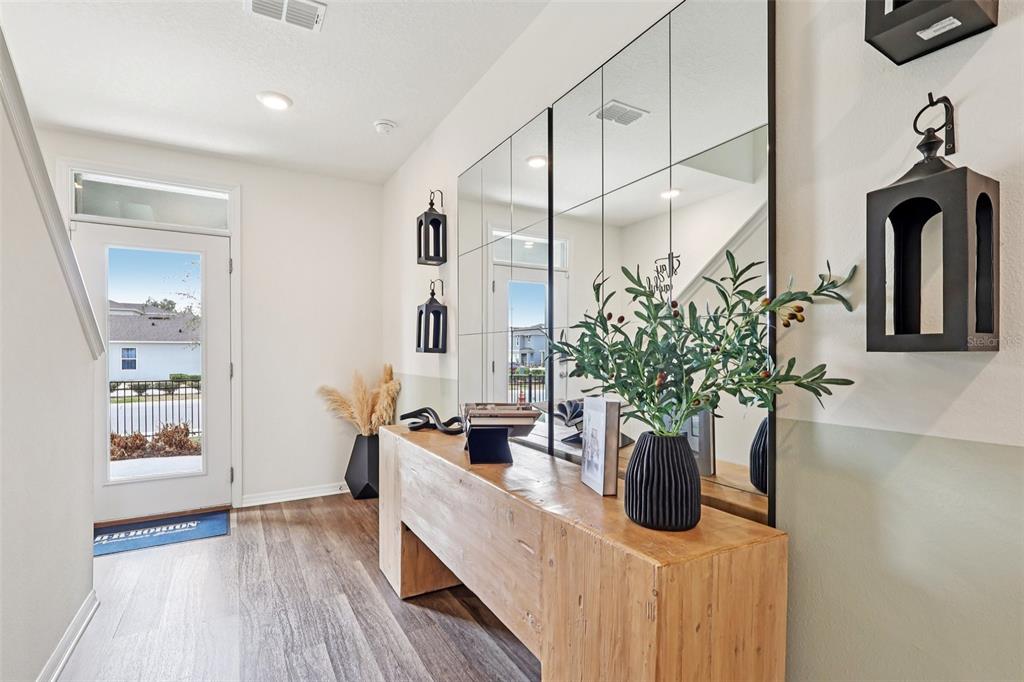 A foyer features a wooden console table, large wall mirrors, and a glass-paneled front door — 4930 KATRINA DRIVE, HAINES CITY, FL