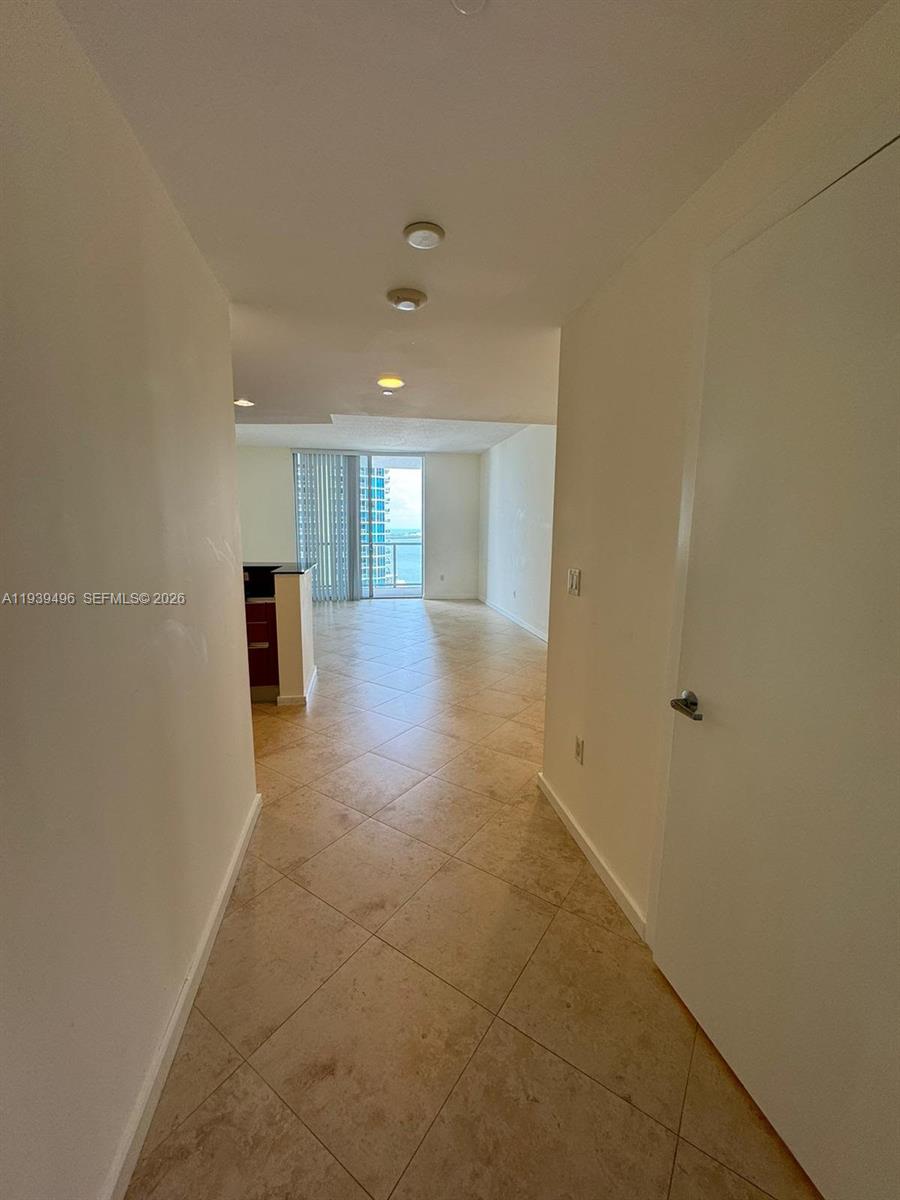A tiled hallway leads to an open living area with floor-to-ceiling windows overlooking water — 1060 BRICKELL AV # 2603, Miami FL 33131, MIAMI, FL