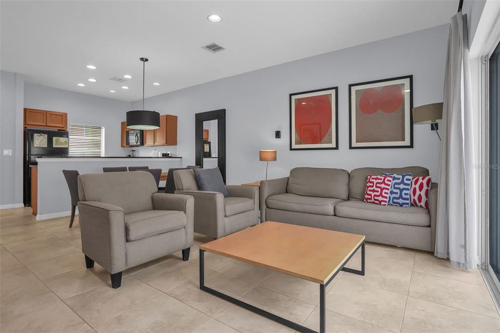 A living room features gray furniture, a light wood coffee table, and two framed wall prints — 3043 WHITE ORCHID ROAD, KISSIMMEE, FL
