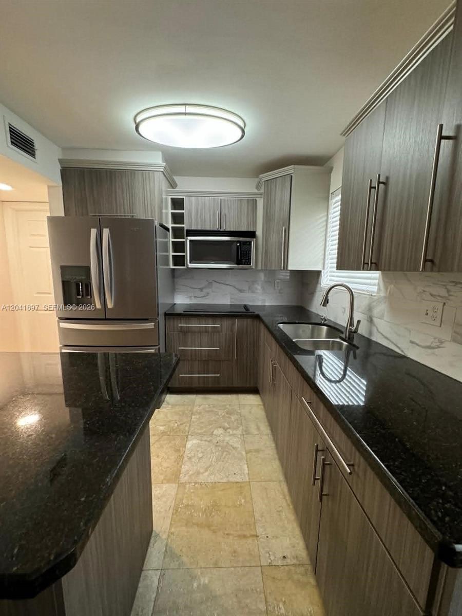 A kitchen features dark wood cabinets, black granite countertops, stainless steel appliances, and tile flooring — 6200 SW 131st Ct # 201, Miami FL 33183, MIAMI, FL