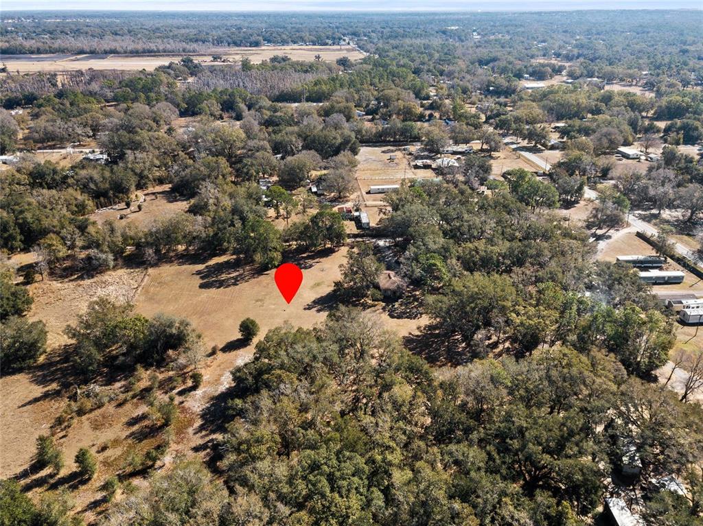 An aerial view shows a large, grassy lot surrounded by trees with a red marker — 4815 1/2 DEESON ROAD, LAKELAND, FL