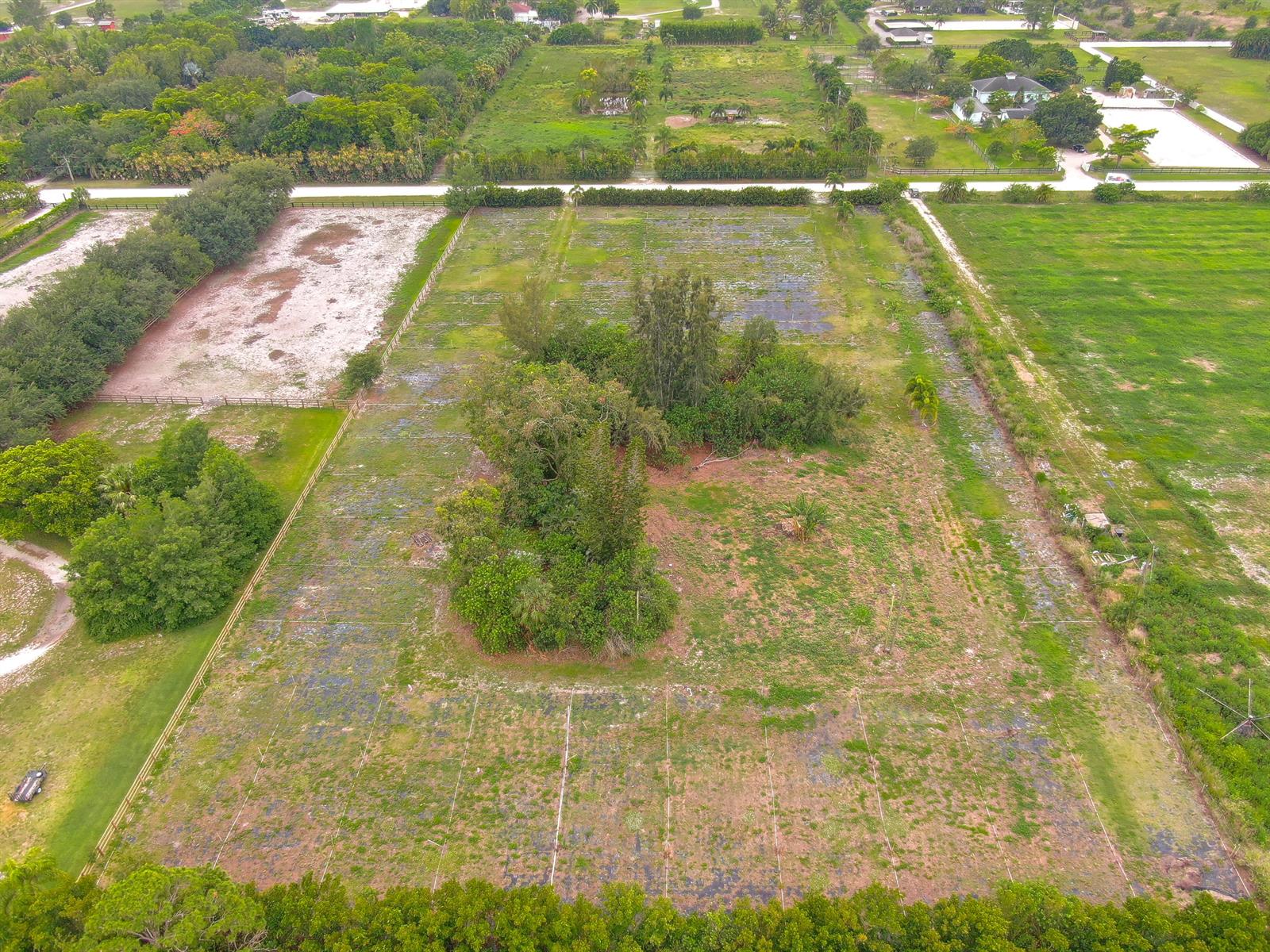 An aerial view shows a large, rectangular plot of land with scattered trees and fencing — 16295 Rustic Road, Wellington FL 33470, WELLINGTON, FL