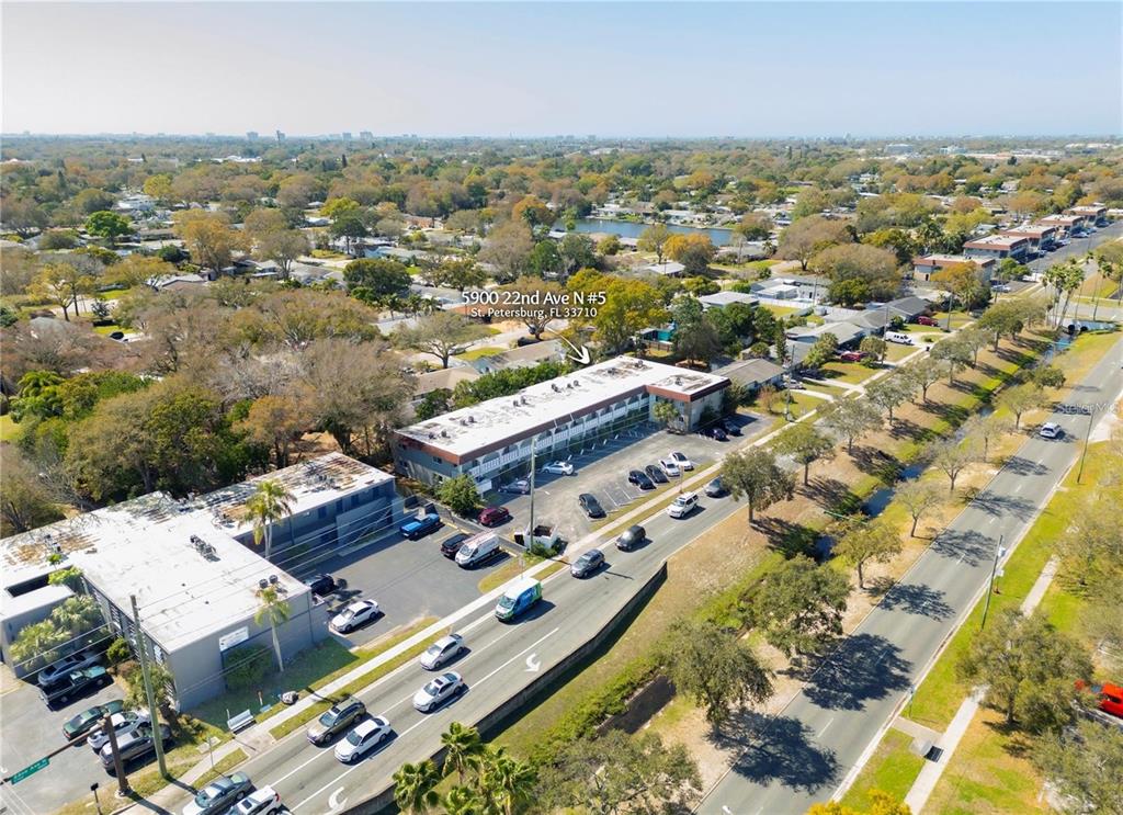 An aerial view shows a two-story commercial building with a parking lot and surrounding trees — 5900 22ND AVENUE N UNIT 14, ST PETERSBURG, FL