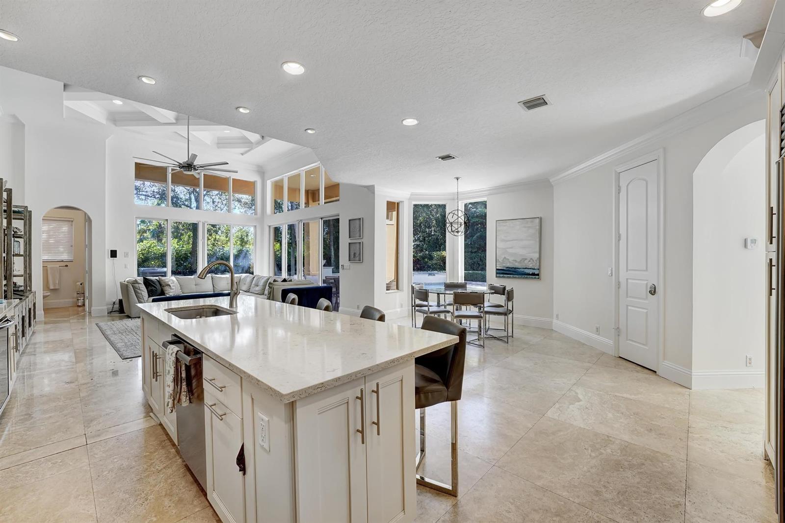 A bright, open-concept kitchen features a large quartz island, tile flooring, and a dining area — 43 Coconut Lane, Ocean Ridge FL 33435, OCEAN RIDGE, FL