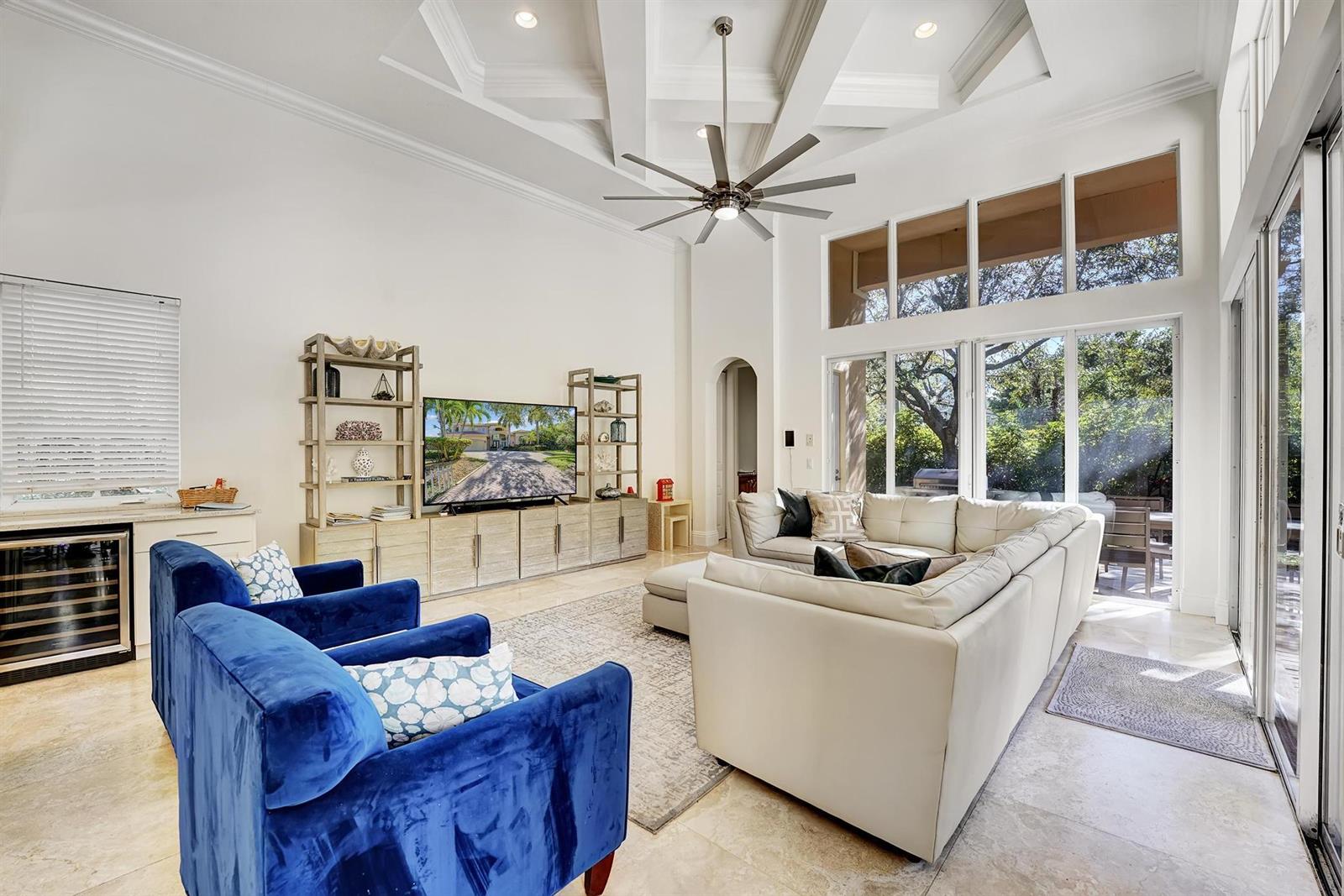 A living room features a vaulted ceiling, a large sectional, blue armchairs, and floor-to-ceiling windows — 43 Coconut Lane, Ocean Ridge FL 33435, OCEAN RIDGE, FL