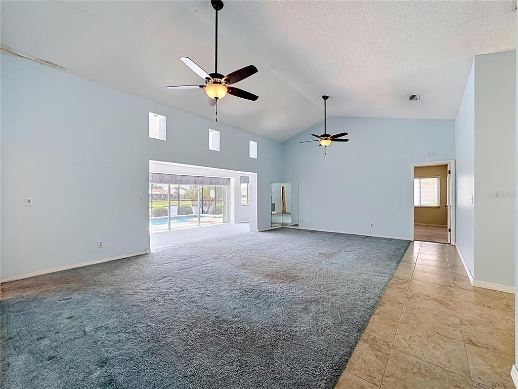 A large, light blue living room features vaulted ceilings, two ceiling fans, and gray carpeting — 2007 WEDGE COURT, SUN CITY CENTER, FL
