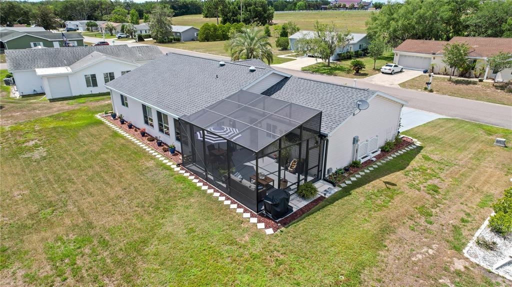 An aerial view of a suburban house with a screened-in patio and a backyard — 10608 SE 174TH LOOP, SUMMERFIELD, FL