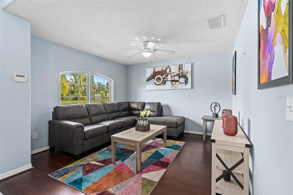 A living room features a grey sectional sofa, a geometric rug, and a coffee table — 1030 COVENTRY ROAD, DAVENPORT, FL