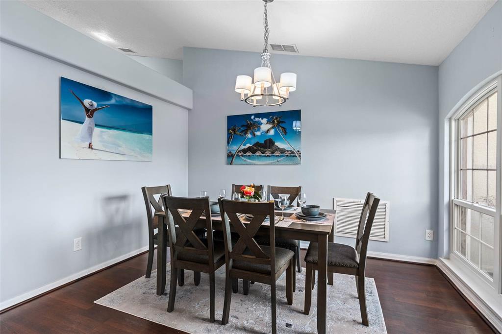 A dining room features a dark wood table with six chairs under a chandelier — 1030 COVENTRY ROAD, DAVENPORT, FL