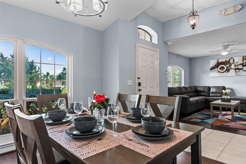 A dining area with a wooden table and chairs opens into a living room — 1030 COVENTRY ROAD, DAVENPORT, FL