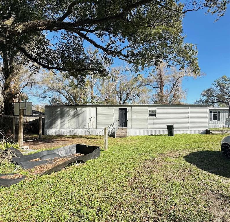 A single-story manufactured home with light gray siding sits on a grassy lot — 711 NASHVILLE ROAD, LAKELAND, FL