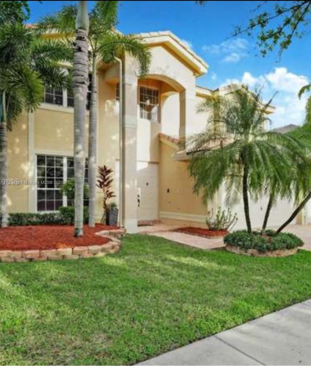 A two-story beige house with a front lawn, palm trees, and a paved walkway — 3181 SW 173rd Ter, Miramar FL 33029, MIRAMAR, FL