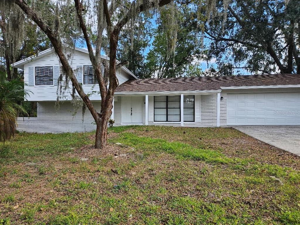 A two-story white house with a garage and a large tree in the front yard — 3610 GREENSTONE PLACE, VALRICO, FL