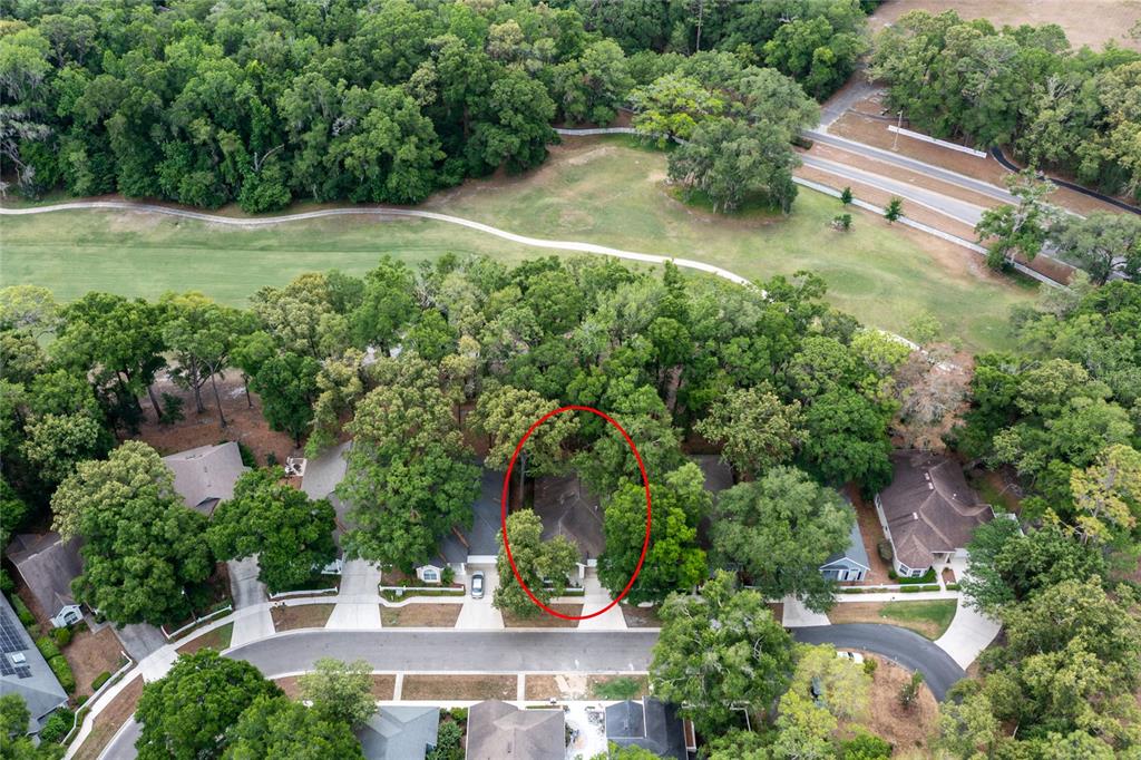 An aerial view shows a residential house surrounded by trees near a golf course — 5231 SW 103RD DRIVE, GAINESVILLE, FL