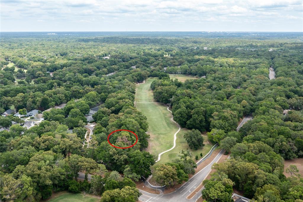 An aerial view shows a wooded lot circled in red next to a golf course — 5231 SW 103RD DRIVE, GAINESVILLE, FL