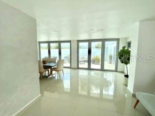 A bright dining area features large glass sliding doors, white tile floors, and a potted plant — 0 ALHAMBRA, GUAYNABO, PR