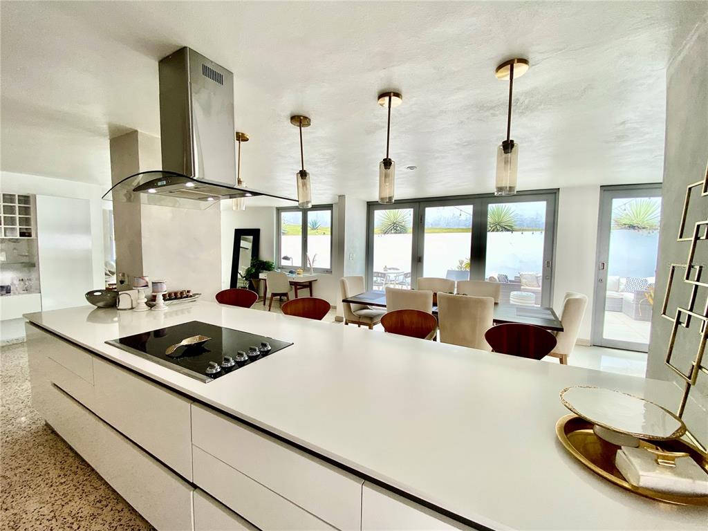 A modern kitchen features a large white island with a cooktop and pendant lighting — 0 ALHAMBRA, GUAYNABO, PR