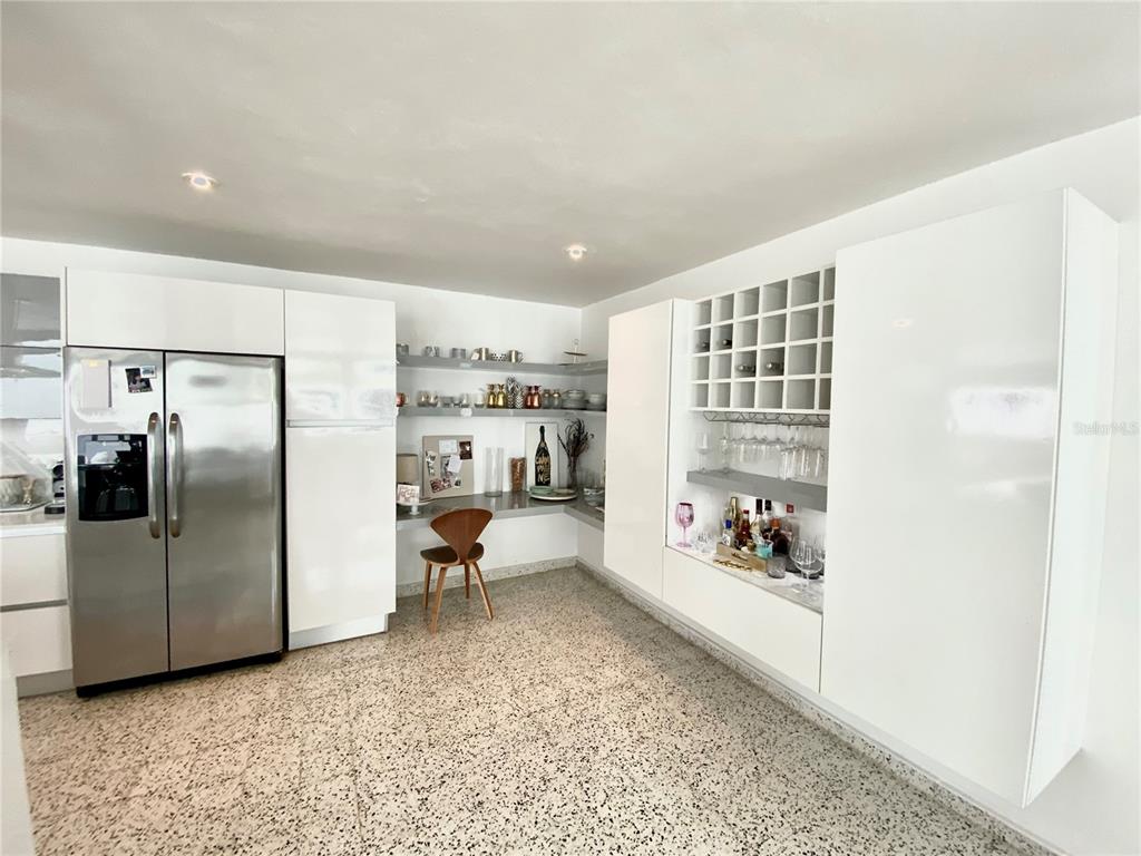A modern kitchen features white cabinetry, a stainless steel refrigerator, a built-in bar, and terrazzo flooring — 0 ALHAMBRA, GUAYNABO, PR
