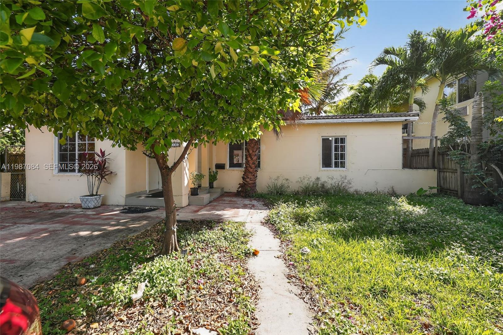 A single-story house with a beige exterior, a front yard, and a large tree — 2131 Biarritz Dr, Miami Beach FL 33141, MIAMI BEACH, FL