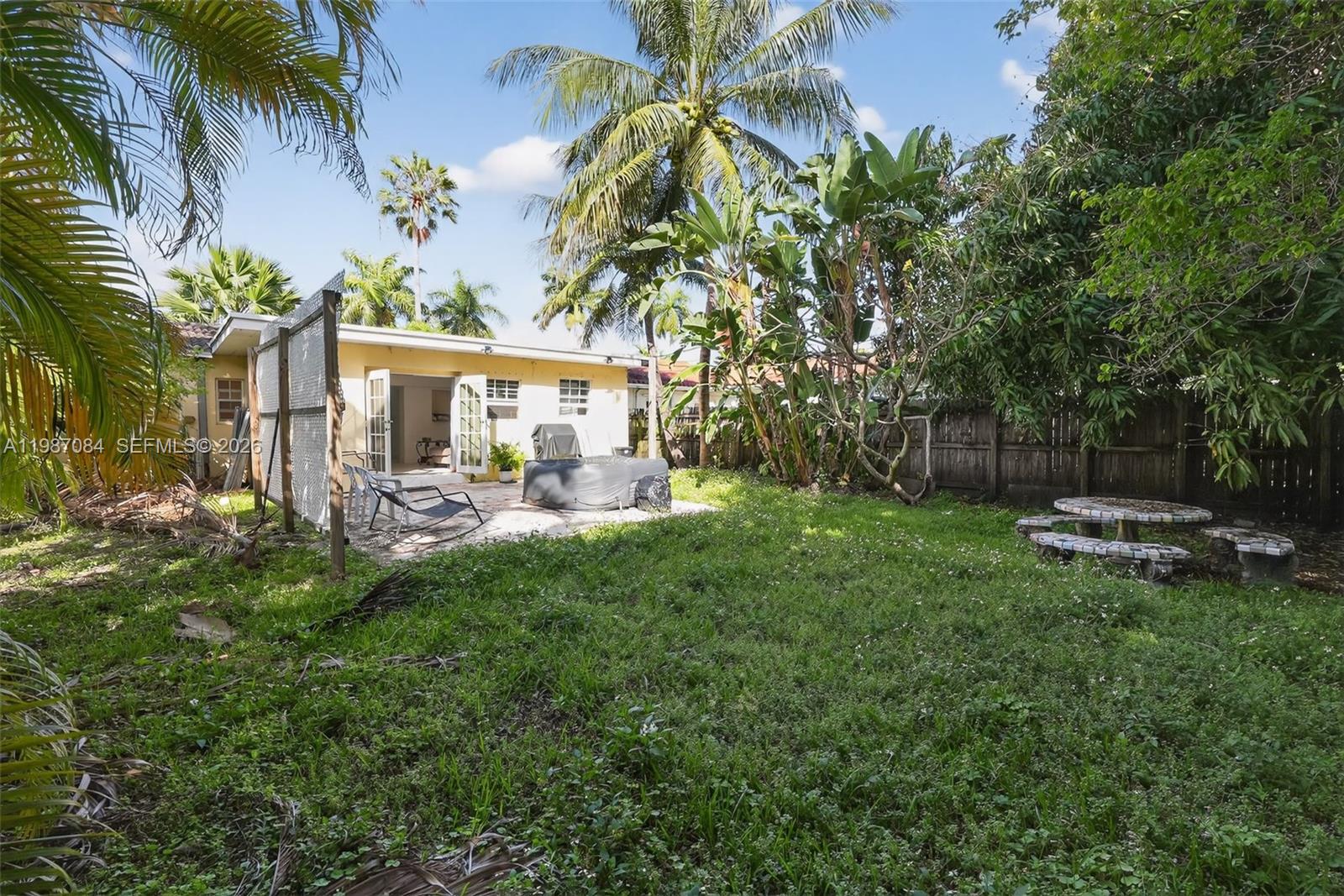 A backyard features a patio with a hot tub, a lawn, and a stone table — 2131 Biarritz Dr, Miami Beach FL 33141, MIAMI BEACH, FL