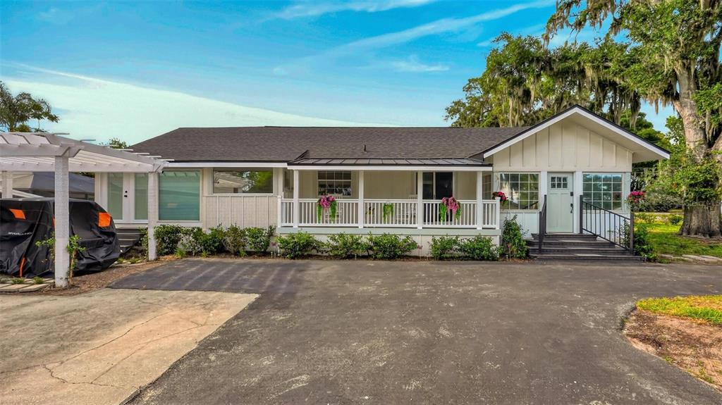 An open-concept living area with light wood flooring, white cabinets, and a sliding glass door — 1099 GROVE AVENUE, MOUNT DORA, FL