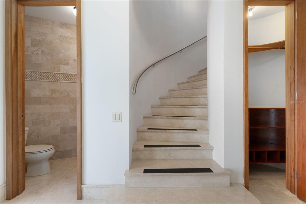 A stone staircase sits between a bathroom on the left and a closet on the right — 500 PLANTATION VILLAGE DRIVE UNIT PH 2-403, DORADO, PR