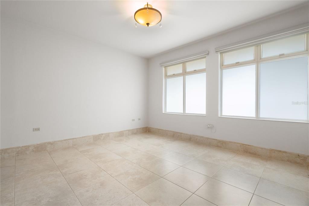 An empty room features white walls, large windows, and light-colored tile flooring — 500 PLANTATION VILLAGE DRIVE UNIT PH 2-403, DORADO, PR