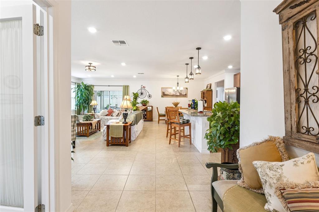 A view from a doorway into an open-concept living room and kitchen with tile floors — 1681 MARSH POINTE DRIVE, CLERMONT, FL