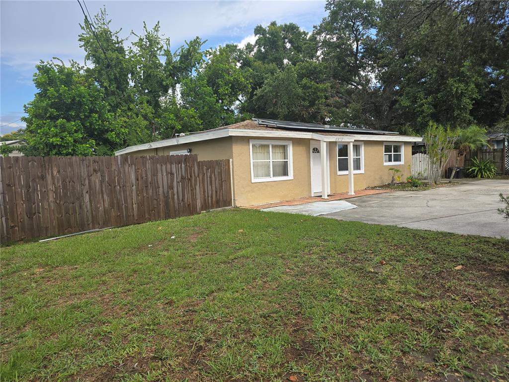 A single-story tan house with a flat roof and a wooden fence in the yard — 2913 MCINTOSH ROAD, SARASOTA, FL
