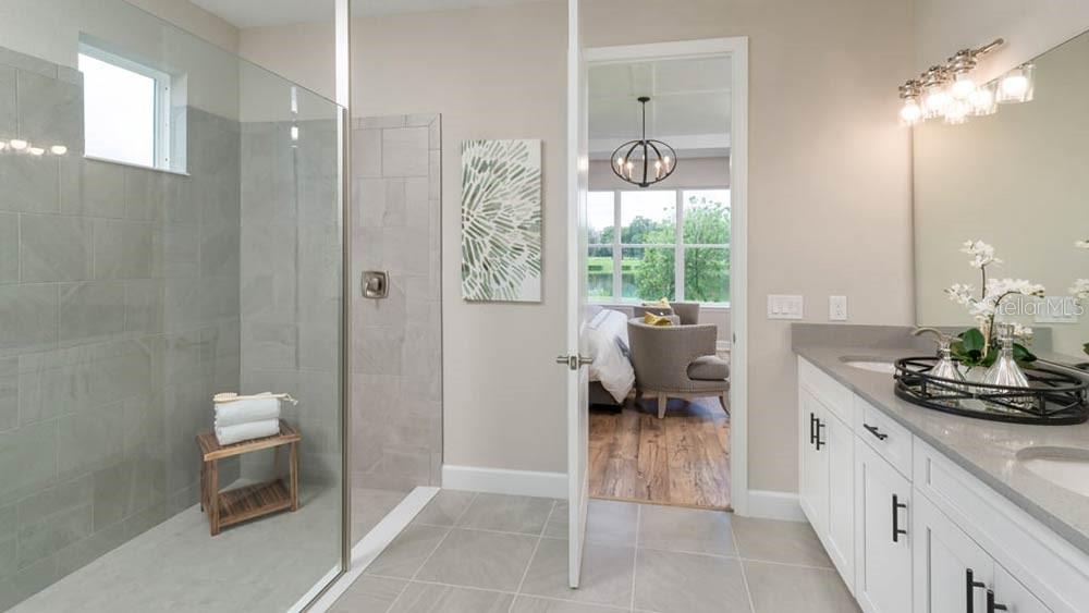 A bathroom with a glass-enclosed shower, double vanity, and a doorway leading to a bedroom — 3614 PINE PEAK LOOP, PLANT CITY, FL