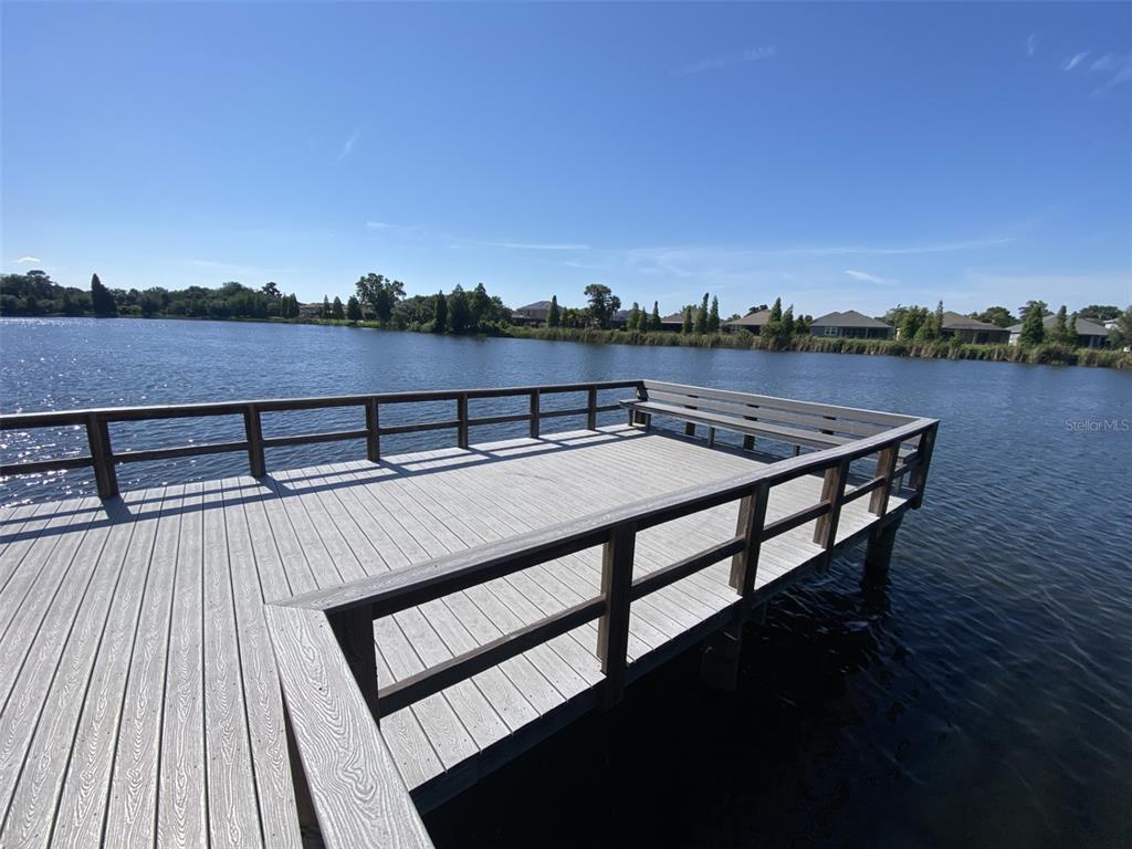 A wooden dock extends over a lake under a clear blue sky — 10422 LAKE MONTAUK DRIVE, RIVERVIEW, FL