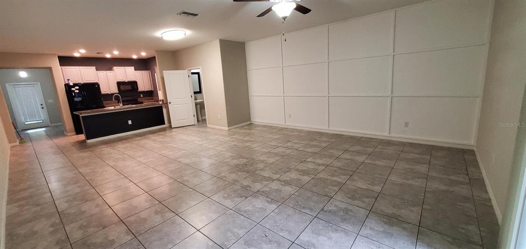 An open-concept living area features large floor tiles and a wall with decorative molding — 10422 LAKE MONTAUK DRIVE, RIVERVIEW, FL