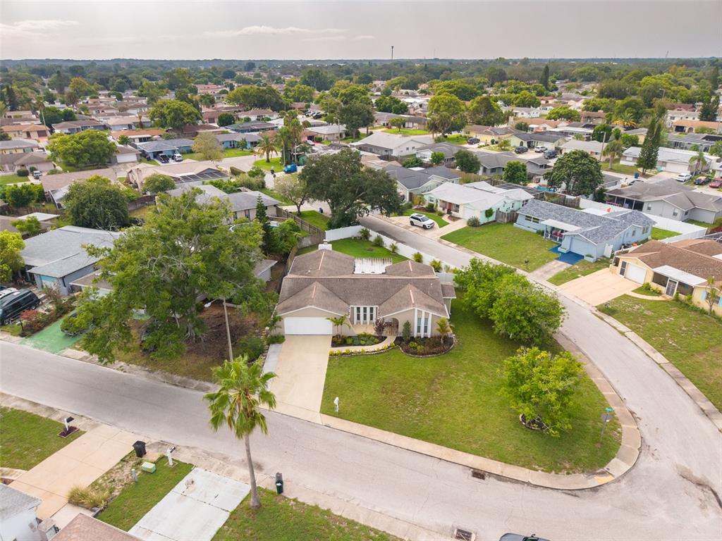 An aerial view shows a single-story suburban house with a tan roof and driveway — 7312 VIENNA LANE, PORT RICHEY, FL