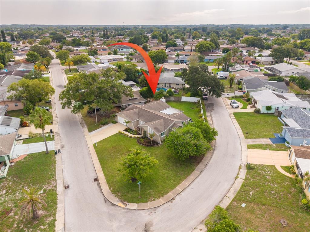 An aerial view shows a single-story house with a pool in a suburban neighborhood — 7312 VIENNA LANE, PORT RICHEY, FL